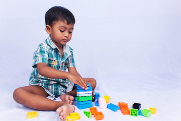 a little asian boy play building brick on white background
