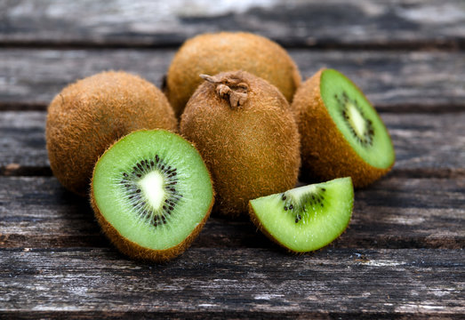 Fresh Green healthy Kiwi Fruits Full and Sliced on Wooden Table Background. rich with vitamin