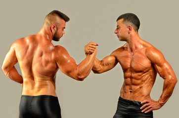 Fototapeta na wymiar Strong bodybuilders testing their biceps in a skandemberg contest