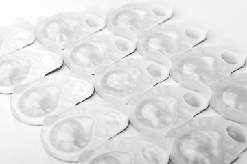 Several packs of contact lens on white surface.