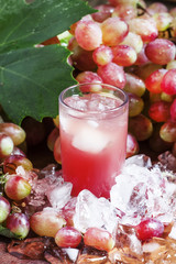 Cool pink grape juice with ice, selective focus