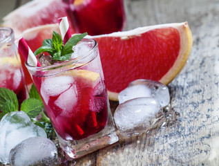 Grapefruit Cocktail with ice in a small glass on old wooden tabl