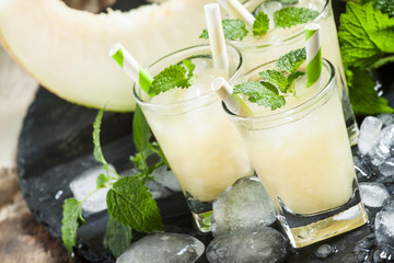 Fresh juice from the pulp of a melon, mint, ice and striped stra