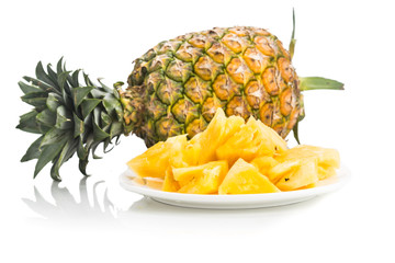 Fresh juicy nutritious cut pineapple with whole fruit as background