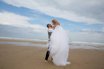 Fototapeta na wymiar Newly wedding couple at the beach in love