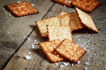 Salty cracker and sea salt on a dark wooden background, toned im