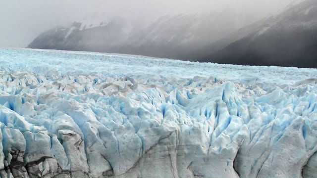 Pan across a vast arctic glacier with ice stretching into the distance.