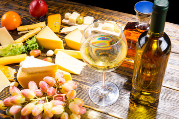 Glass of White Wine on Table with Various Cheeses