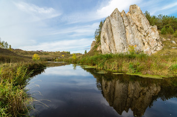 Fototapeta na wymiar пейзаж со скалой возле реки осенью
