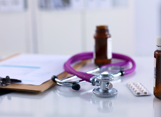 medical stethoscope with pills isolated on white background