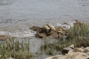 Wellen pl&auml;tschern an gro&szlig;e Steinbrocken 