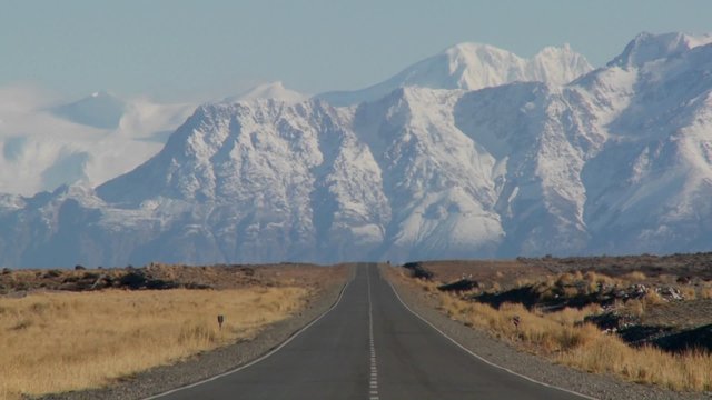 An empty road heading into the Andes mountains in the remote Argentine region of Patagonia.