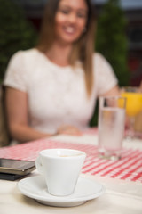 Coffee cup with people in background.