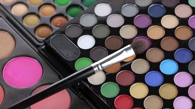 Professional makeup brush and eyeshadows palette, closeup
