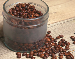 coffee beans in a glass jar on a wooden table