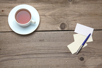 Blank business cards with pen and tea cup on wooden office table