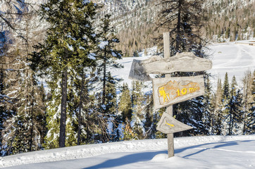 Wooden Sign on a Mountain Trail Covered in Snow 