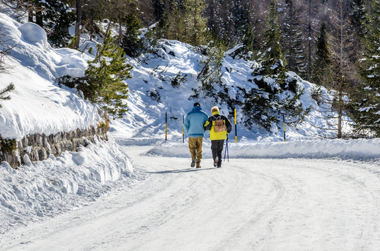 Couple Walking along a Curving Mountain Road in Winter