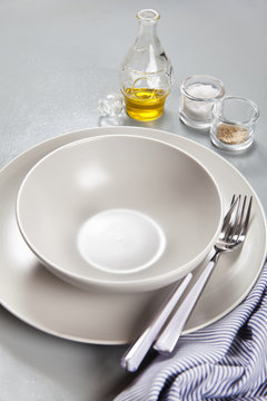 a set of plates and bowls. gray tones. Set of olive oil, salt an