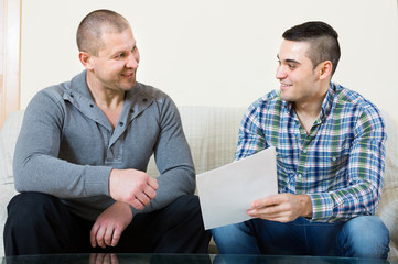 Man helping friend to fill document indoor