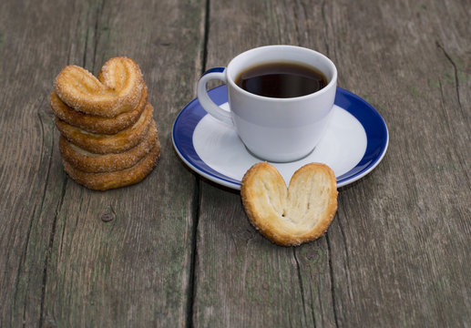 pile of cookies and cup of coffee on a wooden table