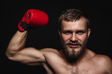 Athletic bearded boxer with gloves on a dark background - 91733604