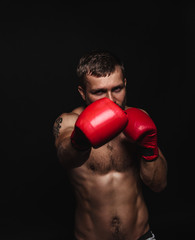 Athletic bearded boxer with gloves on a dark background - 91733624