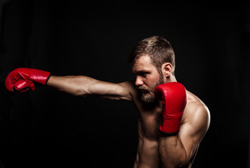 Athletic bearded boxer with gloves on a dark background - 91733693