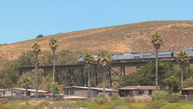 An Amtrak passenger train moves across a bridge in California.