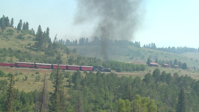 A steam train  travels through Colorado countryside.