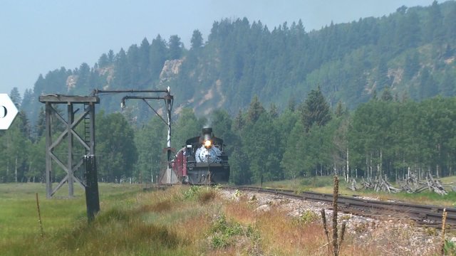 A steam train goes through the Rocky Mountains.
