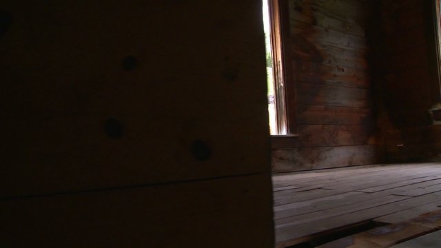 A traveling shot moves into an abandoned house in a ghost town.