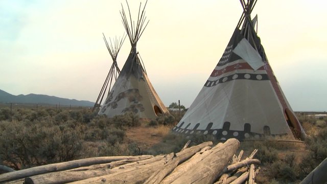 Indian teepees stand in a native american encampment.