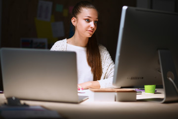 A portrait of a businesswoman staying late in the office.