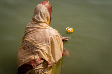 Hindu woman makes and Aarti offering to Shiva on the Ghats of th