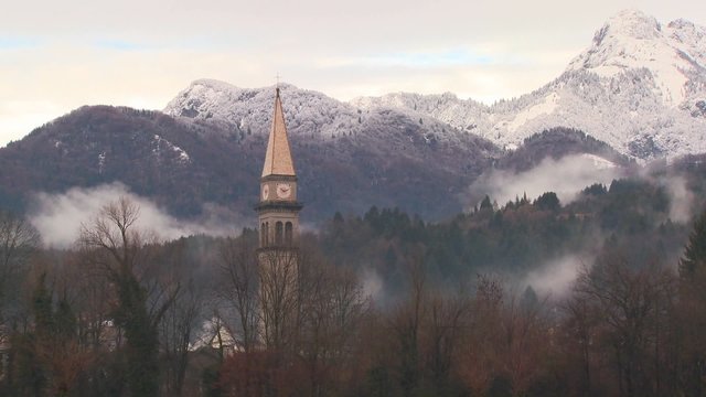 A church is pictured against the Alps of Slovenia, Austria, Switzerland or an Eastern European nation.