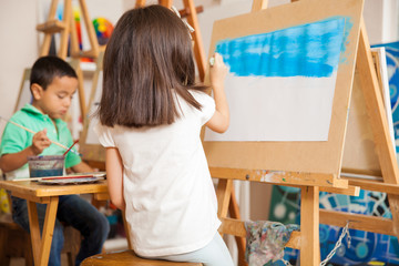 Little girl painting a landscape