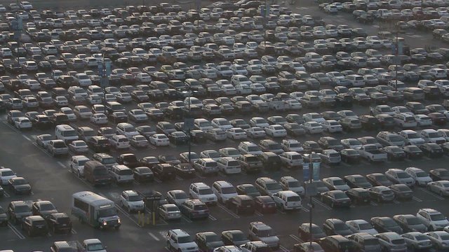 Thousands of cars in a crowded parking lot.