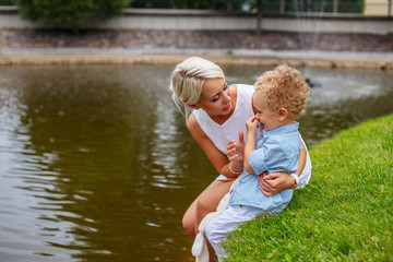 Fototapeta premium Blond female relaxing with her child in a park.