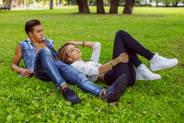 Fototapeta premium Young couple lying on grass field.