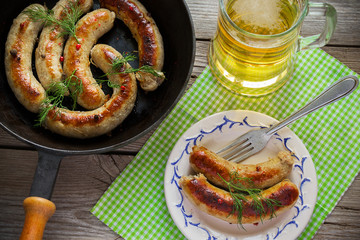 Fried sausages with spices on a wooden background