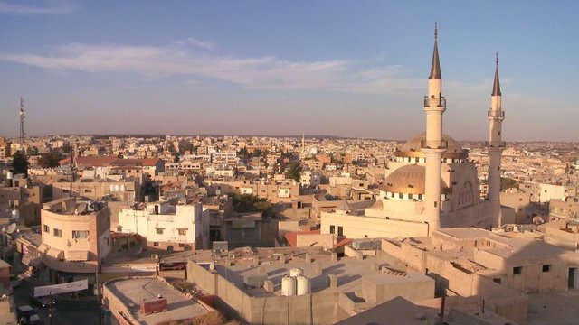 Beautiful generic wide shot of a mosque towering above the Arab city of Madaba in Jordan.