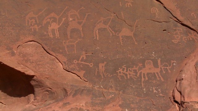 Ancient and mysterious petroglyphs depict humans and camels in the Saudi desert near Wadi Rum, Jordan.