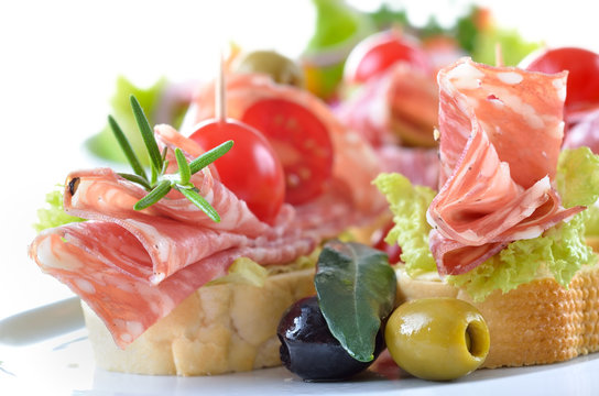 Partyh&auml;ppchen mit feiner italienischer Salami,  Salatblatt und Cherrytomate