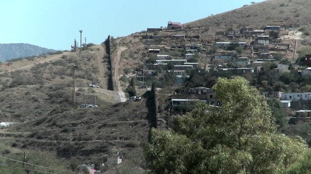 A landscape view of a hilltop community separated with a large wall.