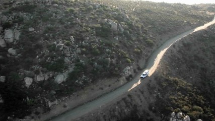 Aerial view of a border patrol vehicle on a rocky dirt road.