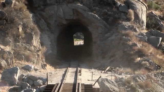 Train tracks go through a tunnel.