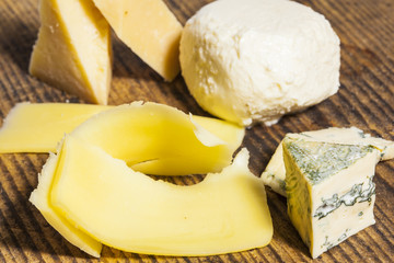 Different types of cheese on a wooden board