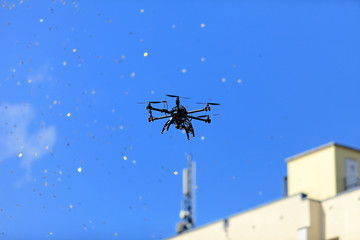 Dron latający na tle błękitnego nieba. - obrazy, fototapety, plakaty