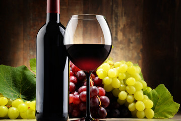 Fototapety  Kompozycja ze szkłem, butelką czerwonego wina i świeżymi winogronami